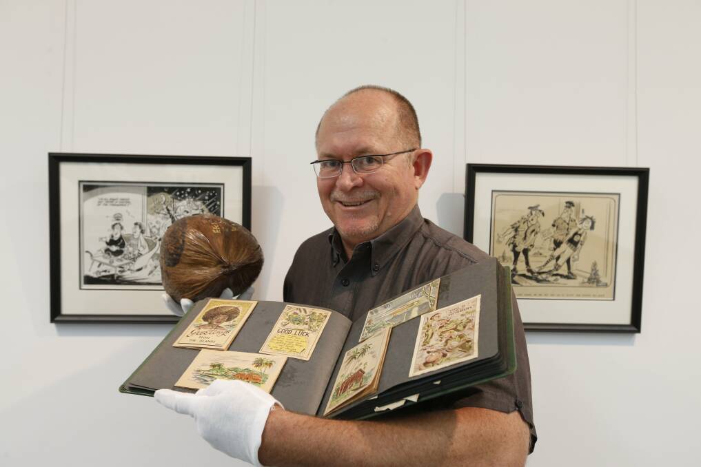 WARTIME ART: Military historian David Dial displays Les Lumsdon's album and coconut letter. Picture: DEAN OSLAND