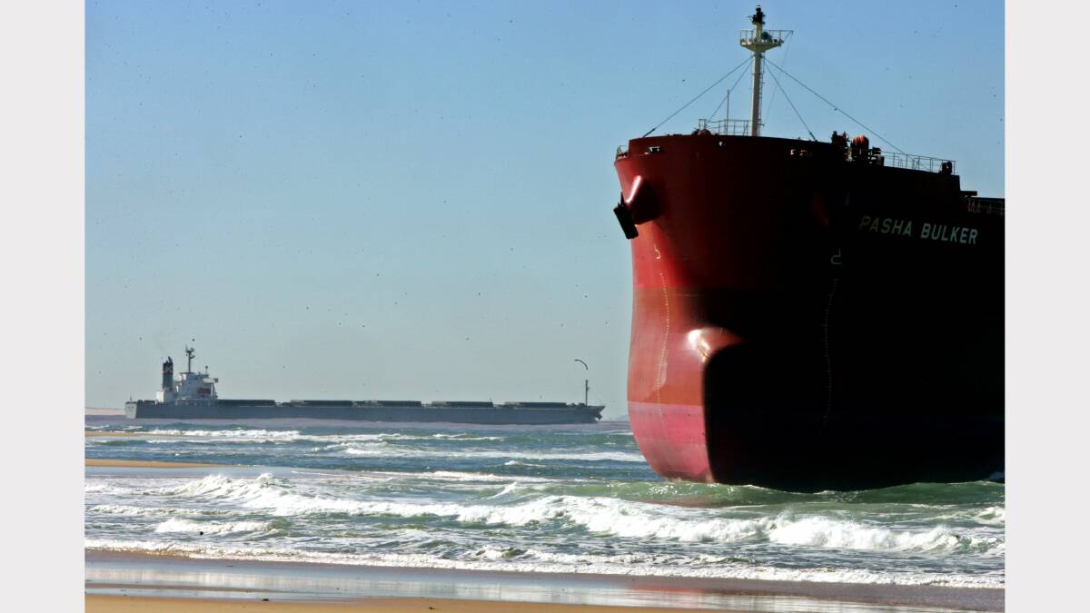  A ship leaves Newcastle Port and heads out to sea as the Pasha Bulker sits stranded on Nobbys Beach after wild storms hit Newcastle last weekend. June 13th 2007 NCH NEWS, Credit: KITTY HILL 