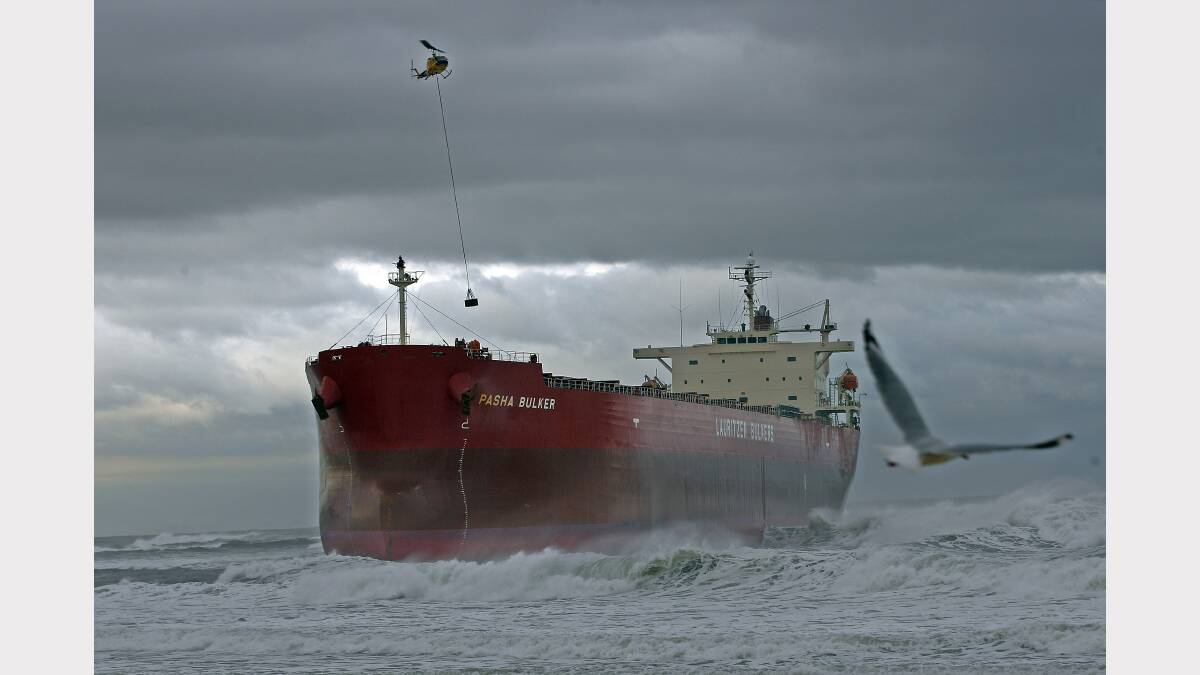 A helicopter lowers salvage equipment to the deck of the 30,000-tonne bulk coal carrier 'Pasha Bulker' which ran aground in wild seas off a beach in Newcastle, north of Sydney, 09 June 2007. Fears are mounting that the ship will break apart and spill its 700 tonnes of fuel oil onto the city's beaches. Credit: Torsten BLACKWOOD